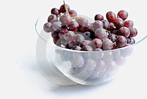 bunch of grapes closeup in glass bowl on white background