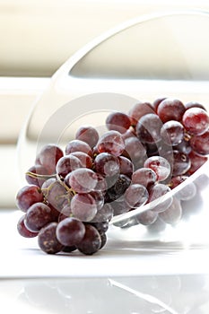 bunch of grapes closeup in glass bowl on white background