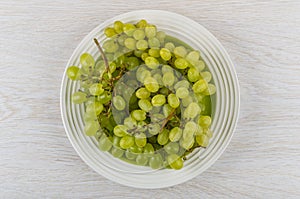 Bunch of grapes in plate on table. Top view