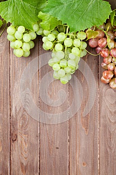 Bunch of grapes and vine on wooden table