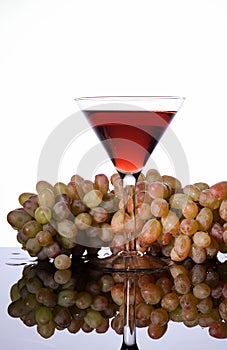 A bunch of grapes and wine in a glass