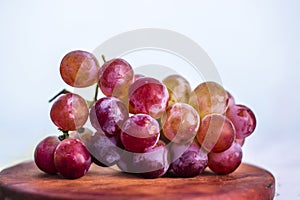 Bunch of grapes on wooden plate