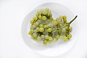 A bunch of green grapes on a white plate close-up