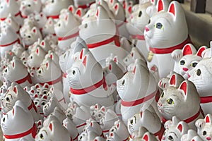 Bunch of Japanese manekineko cat lucky charms in Buddhist gotokuji temple.