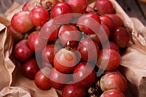 A bunch of juicy large red grapes in a paper bag