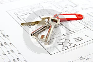 Bunch of keys with red keychains at architectural drawing photo