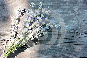 Bunch of lavender flowers on gray weathered wooden background.