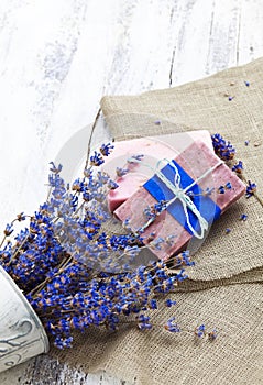 Bunch of lavender flowers,soap on old wooden background.Spa tre