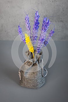 A bunch of lavender and yellow spikelets in a linen bag