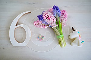 Bunch of light pink and purple hyacinths and white wooden number six. Sixth birthday or anniversary concept