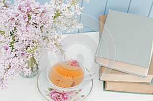Bunch of lilac, books and teacup