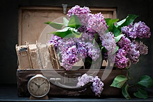 Bunch of lilac flowers in a vintage suitcase. Bouquet of purple lilac flowers