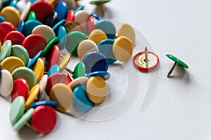 Bunch of many colorful thumbtacks as multi-color office supply metal pushpins circles in yellow, green, blue, red and white desk