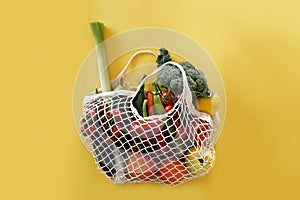 Bunch of mixed organic fruit, vegetables & greens in reusable cotton string net bag.