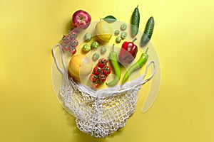 Bunch of mixed organic fruit, vegetables & greens in reusable cotton string net bag.