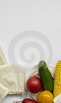 Bunch of mixed organic vegetables and empty reusable cotton bag on a table. Zero waste concept. Eco friendly lifestyle