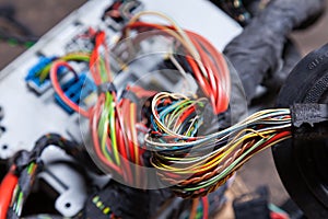 Bunch of multi-colored electrical wires - blue, green, red and yellow, rewound with insulating tape leading to the connectors