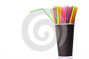 Bunch of multi colored plastic straws in black disposable biodegradable cup