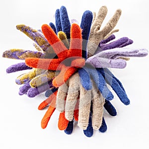 Bunch of new multicolored felted gloves on gray