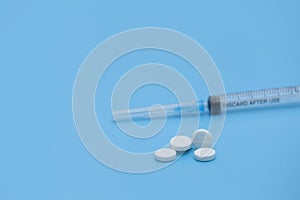 A bunch of pills and tablets on a blue background. Isolated. Copy space. Macro of white capsules on rwhite background