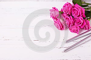 Bunch of pink roses flowers and two silwer candles on white w photo