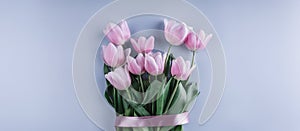 Bunch of pink tulip flowers on blue background. Waiting for spring. Happy Easter card.
