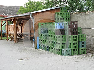 Bunch of plastic storage boxes near a wooden construction with table and chairs