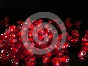 A bunch of pomegranate grains close up. Black background.