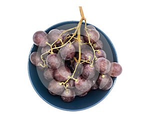 Bunch of purple grapes in a plate isolated on white background