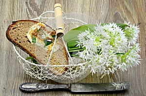 Bunch of ramson wild garlic flower heads and leaves on basket wi