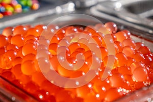 Bunch of red bobas with a flavor of pomegranate in a shop. Ingredient used to make bubble tea.