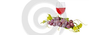 Bunch of red grapes and leaves and red wine glass on white background