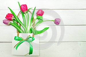 Bunch of red and purple tulips on white wooden background with copy space like postcard on womens day