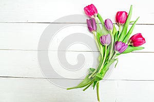 Bunch of red and purple tulips on white wooden background with copy space like postcard on womens day