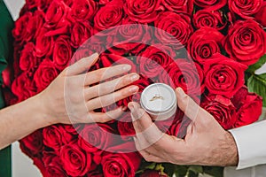 Bunch of red roses, wedding ring and love - all you need for marriage proposal.