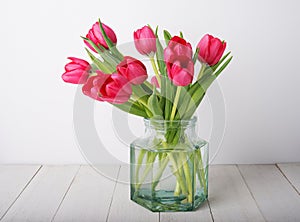Bunch of red tulip flowers in a glass vintage jar