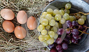 Bunch of red and white grapes with eggs in the straw