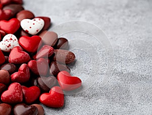 A bunch of red and white hearts on a gray surface