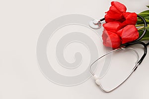 Bunch of redtulips and stethoscope on white background. National