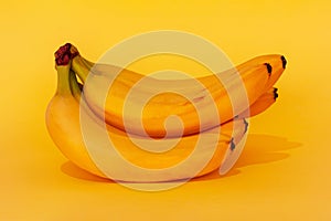 a bunch of ripe bananas on a yellow background close-up.