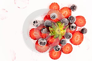 Bunch of ripe, fresh, natural red cut strawberries and blueberries, a healthy spring and summer fruit, on white background