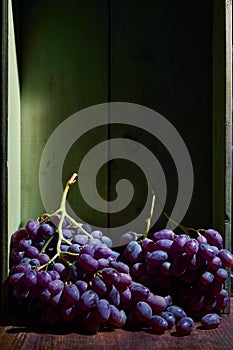 Bunch of ripe organic grown grapes in a wooden box in bright sunlight with copyspace. Natural fruit from garden concept image