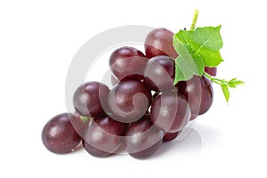 Bunch of ripe red grape fruit with green leaves isolated on white.