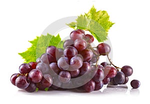 Bunch of ripe red grapes with leaves isolated on white