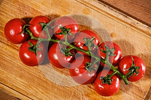 bunch of ripe red tomatoes on a cutting board