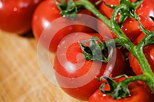 bunch of ripe red tomatoes on a cutting board