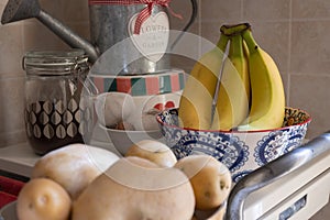 Bunch of Ripe Yellow Bananas inside a Hand Painted Ceramic Pottery Bowl in the Kitchen