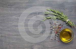 Bunch of rosemary, condiment and olive oil on the wooden backgro