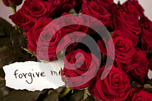 A bunch of roses in vase with note - forgive me