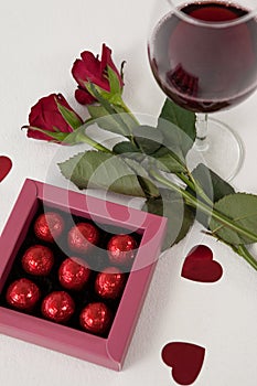 Bunch of roses, wine glass and assorted chocolate box